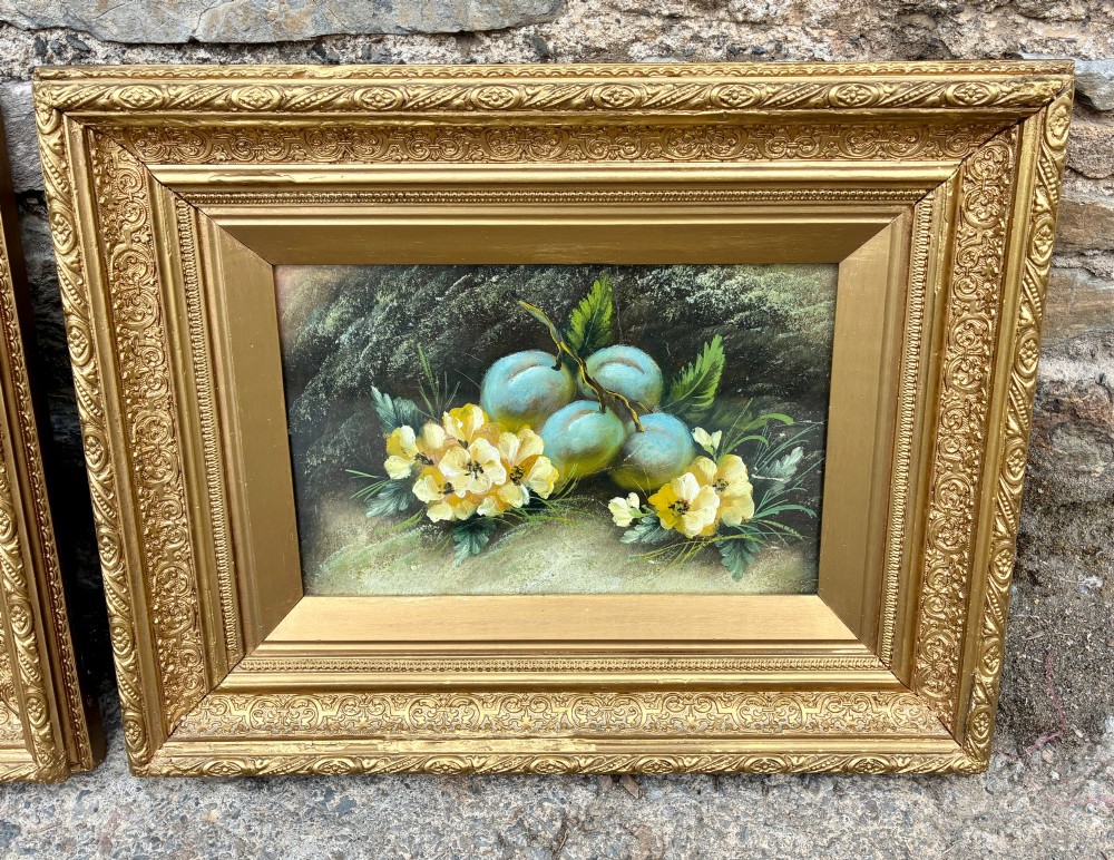 A matching pair of Victorian still life oil paintings depicting plums, primroses, and a bird nest in ornate gold gilded frames. View III