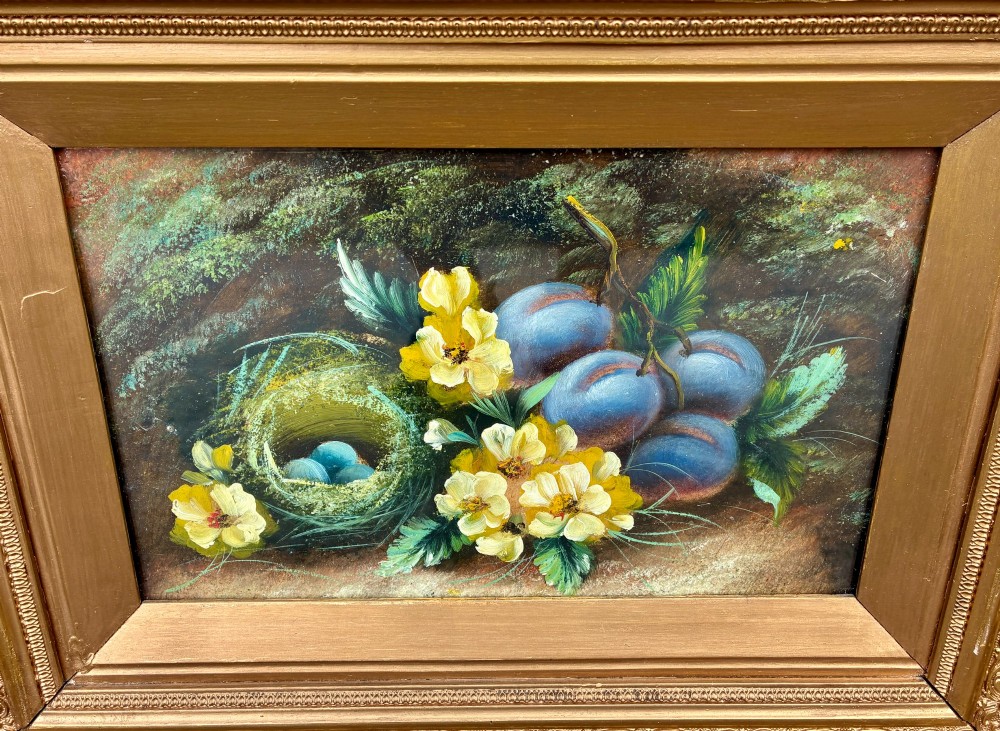 A matching pair of Victorian still life oil paintings depicting plums, primroses, and a bird nest in ornate gold gilded frames. View V