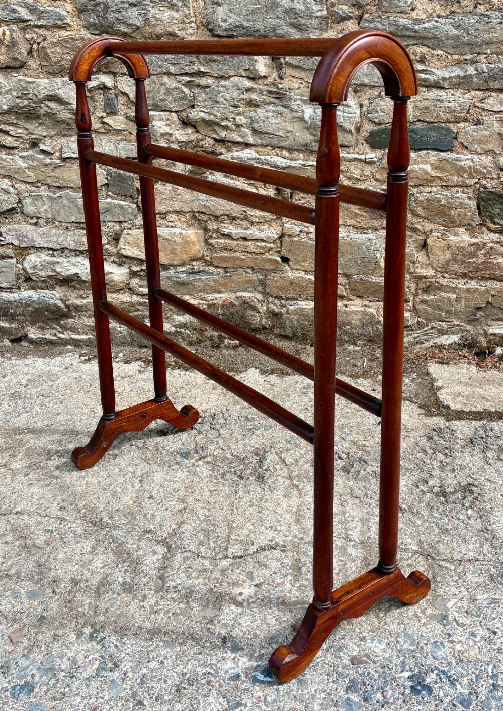 A freestanding Victorian mahogany towel rail featuring arched top cresting, turned upright supports, four horizontal bars, and shaped trestle feet. View VIII