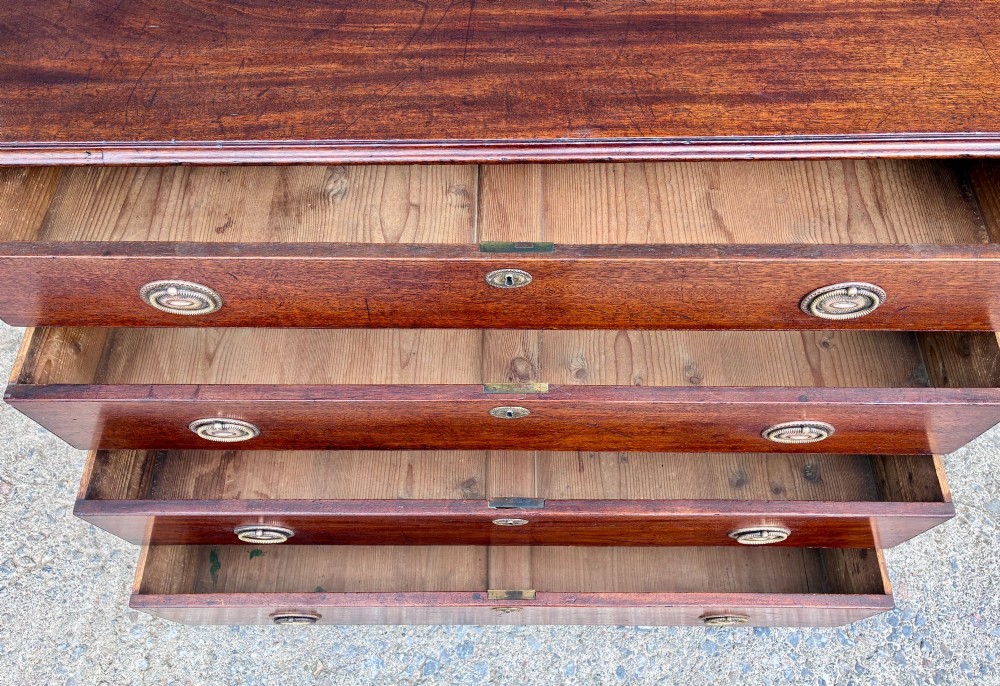 A Georgian mahogany chest of drawers featuring four graduated drawers with circular brass ring pull handles and bracket feet. View VI