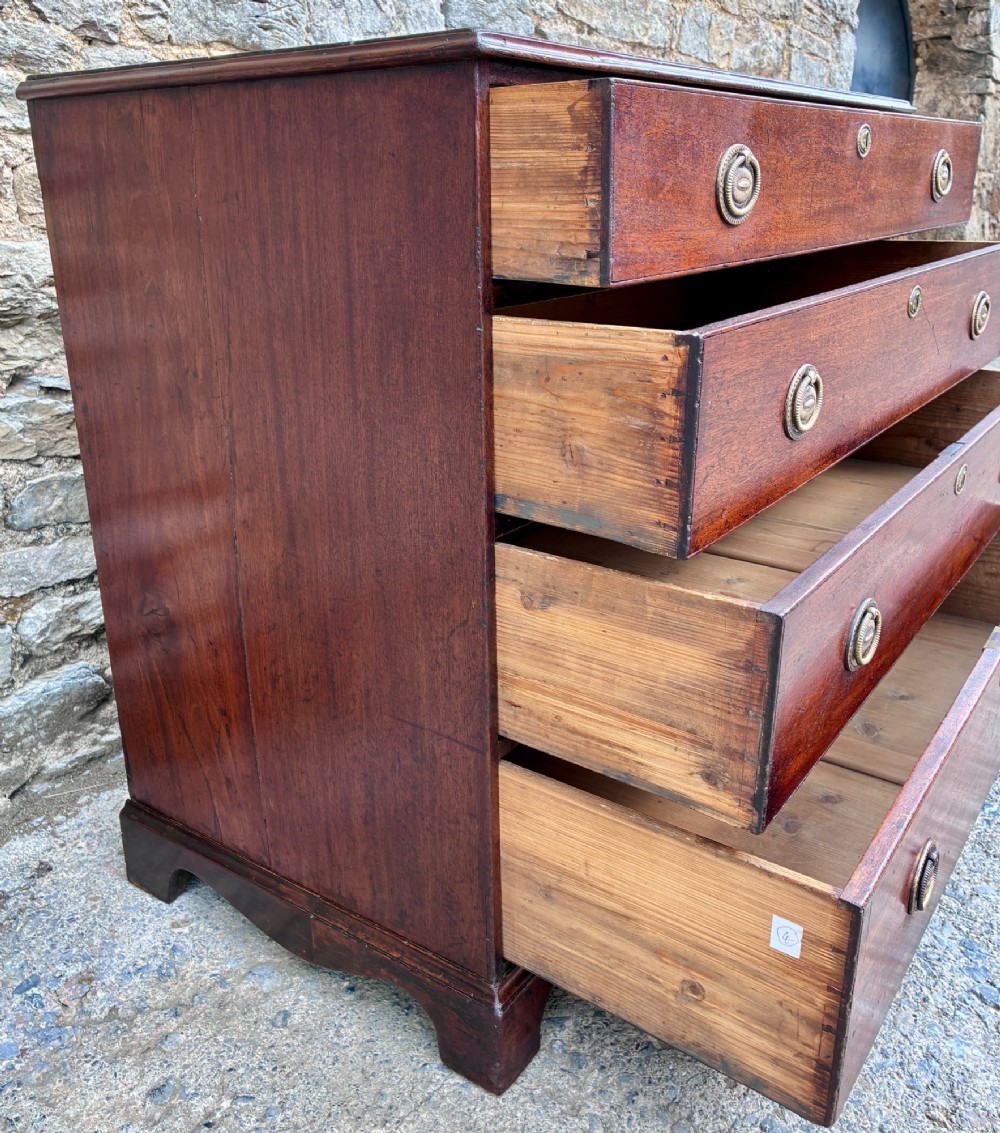 A Georgian mahogany chest of drawers featuring four graduated drawers with circular brass ring pull handles and bracket feet. View VII
