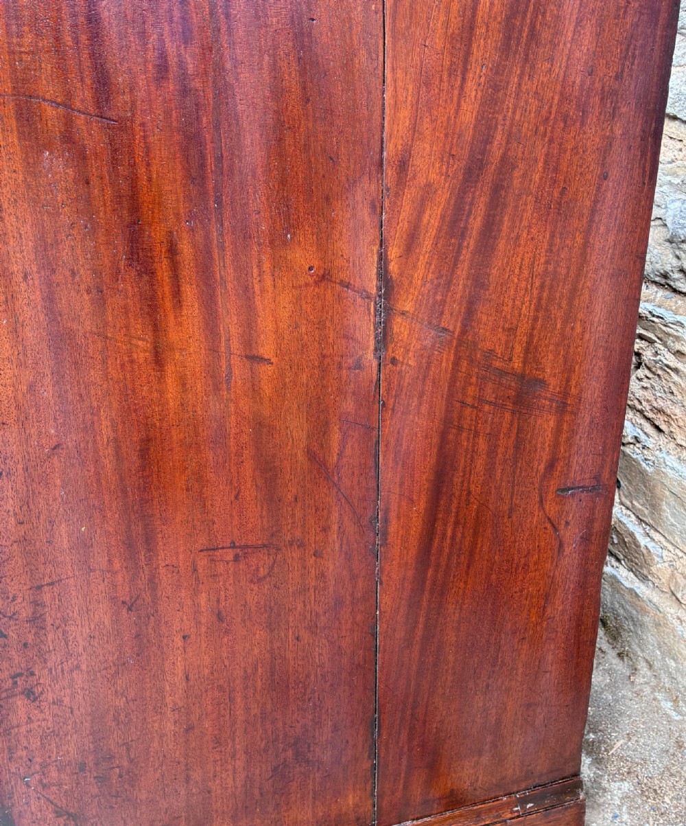 A Georgian mahogany chest of drawers featuring four graduated drawers with circular brass ring pull handles and bracket feet. View IX