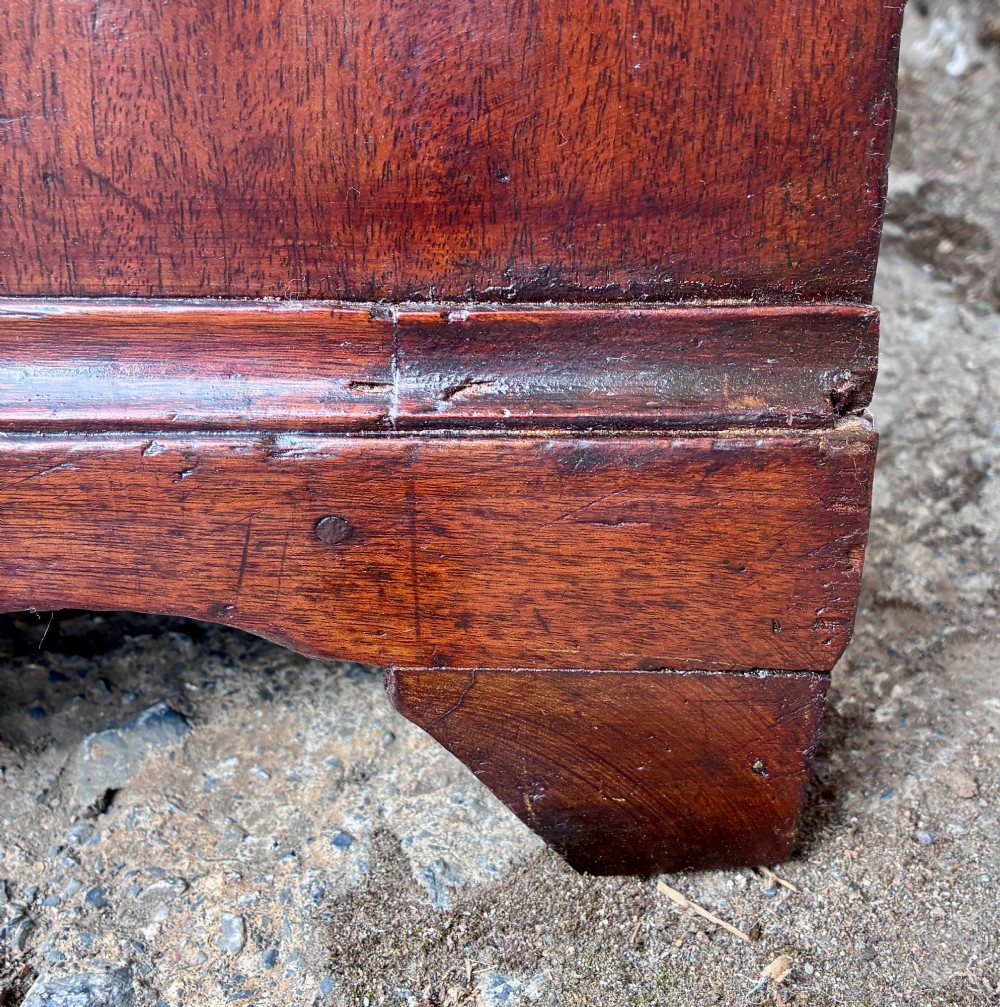 A Georgian mahogany chest of drawers featuring four graduated drawers with circular brass ring pull handles and bracket feet. View X