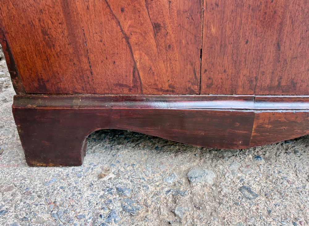 A Georgian mahogany chest of drawers featuring four graduated drawers with circular brass ring pull handles and bracket feet. View XI