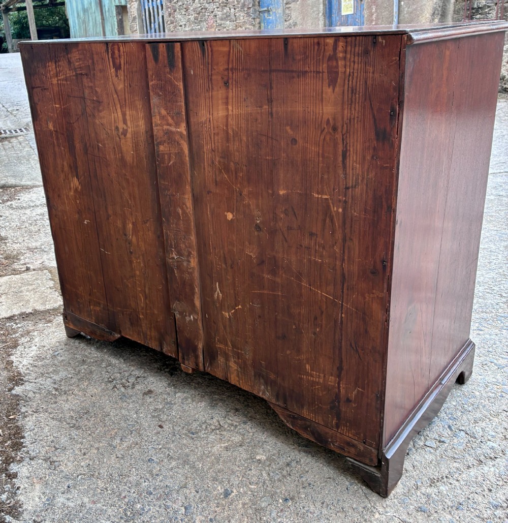 A Georgian mahogany chest of drawers featuring four graduated drawers with circular brass ring pull handles and bracket feet. View XII