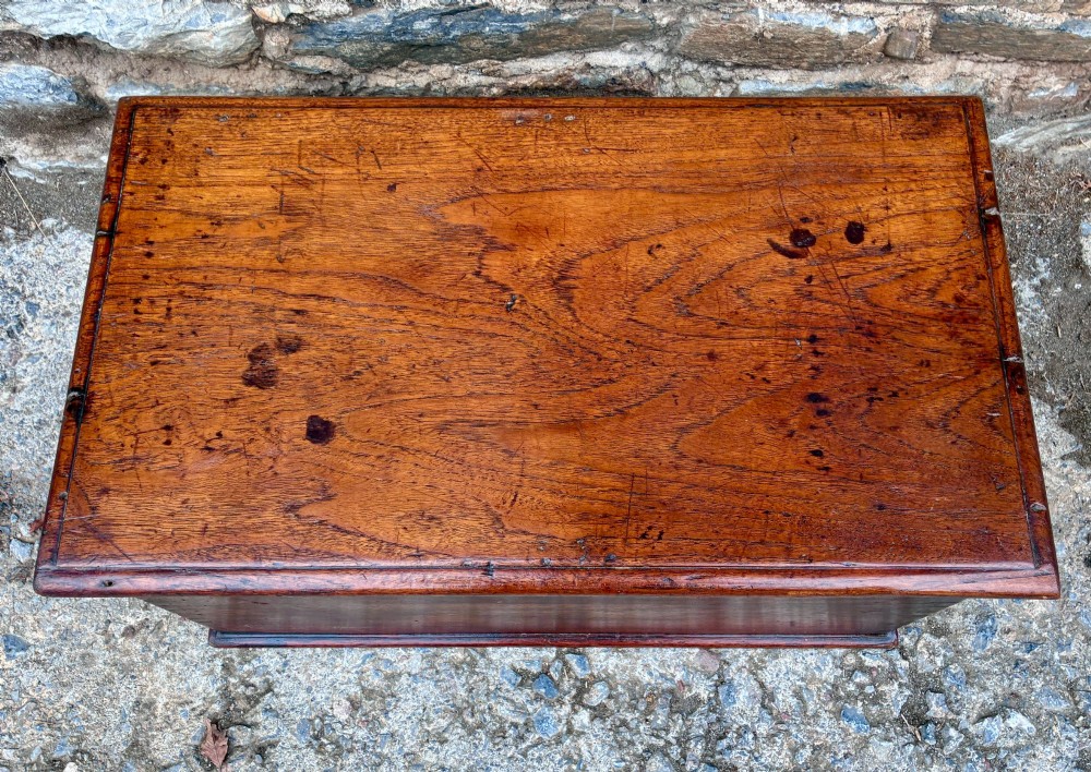 A rectangular warm brown teak storage chest featuring dovetailed corner joints and a central brass keyhole escutcheon. View II