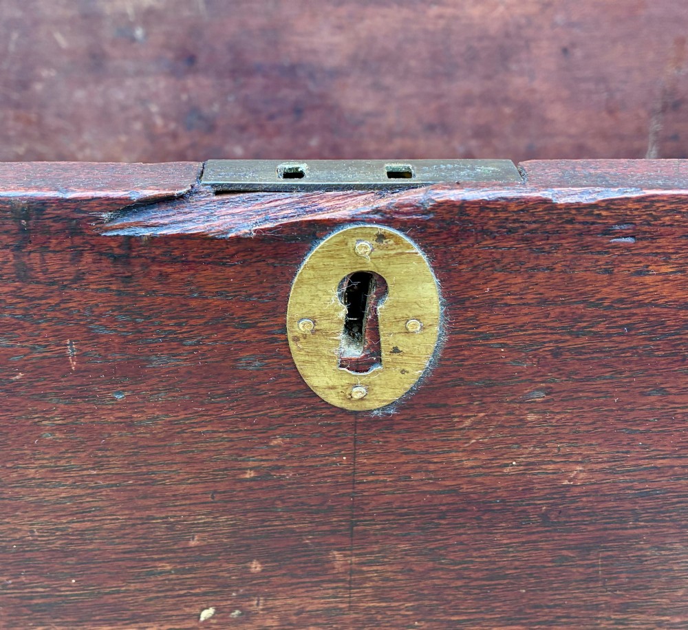 A rectangular warm brown teak storage chest featuring dovetailed corner joints and a central brass keyhole escutcheon. View V