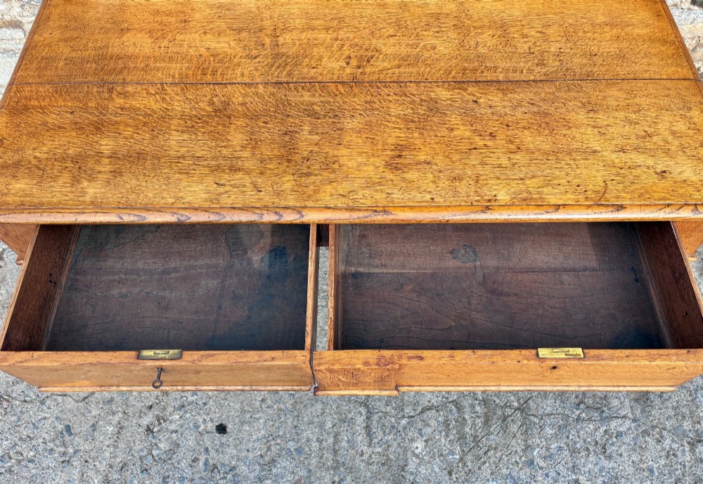 A Victorian golden oak console table featuring a rectangular top with a moulded edge, two frieze drawers, and four turned legs. View V