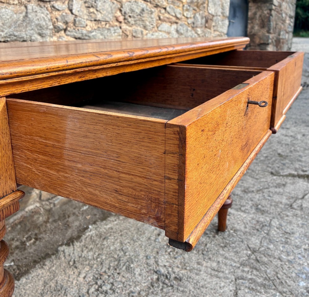 A Victorian golden oak console table featuring a rectangular top with a moulded edge, two frieze drawers, and four turned legs. View VII