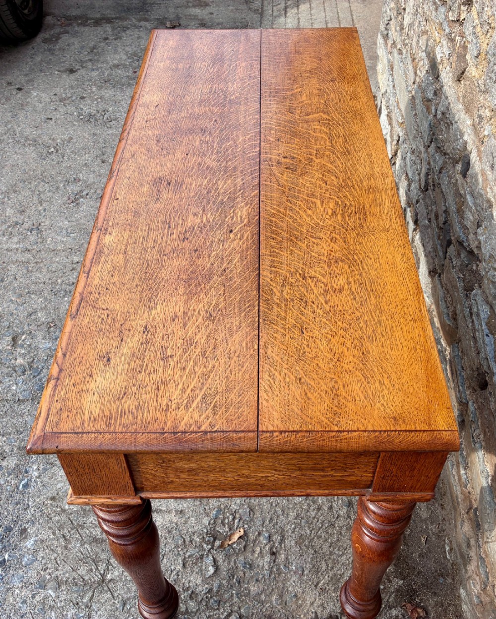 A Victorian golden oak console table featuring a rectangular top with a moulded edge, two frieze drawers, and four turned legs. View XI