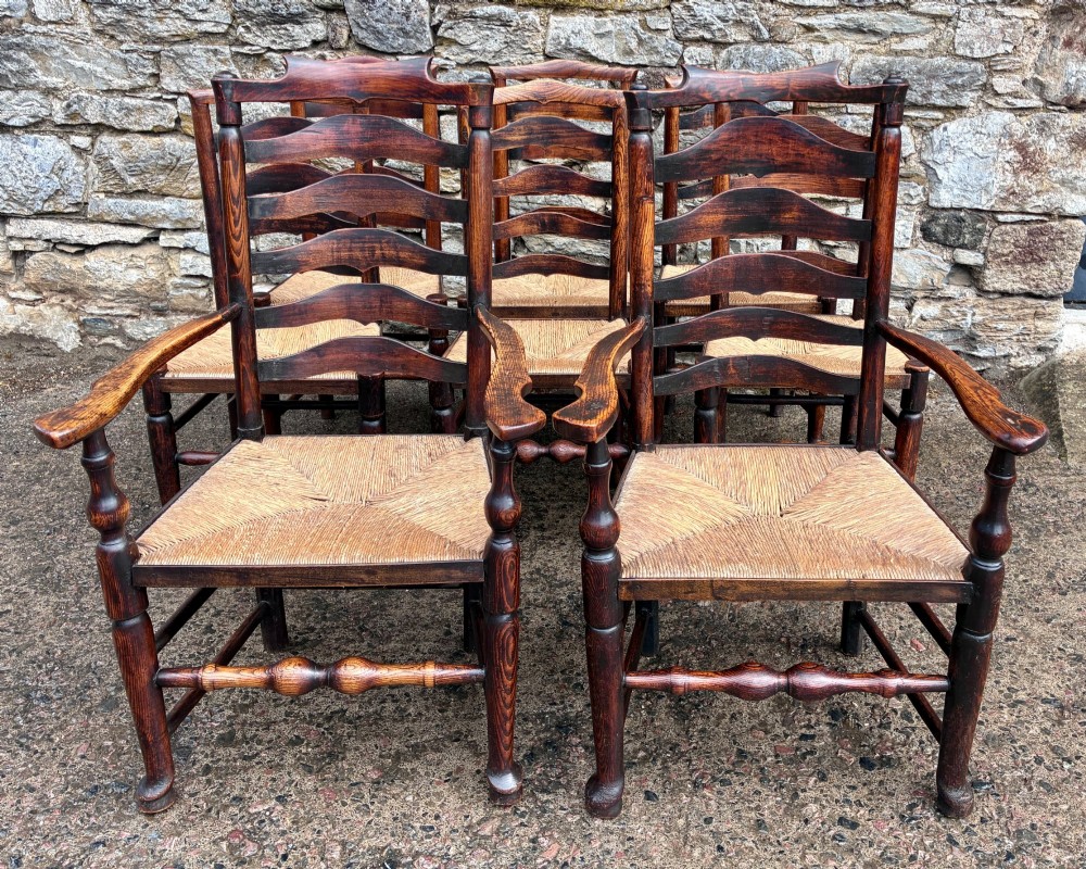 A set of eight 19th-century dark timber Lancashire ladderback dining chairs featuring wavy back slats, turned front stretchers, and woven rush seats, comprising two carver armchairs and six side chairs. View II