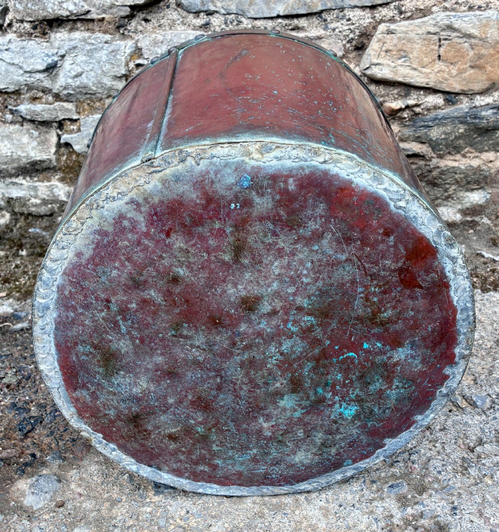 A cylindrical copper bucket featuring a riveted top band, a swing metal handle, and visible green verdigris patination. View VIII