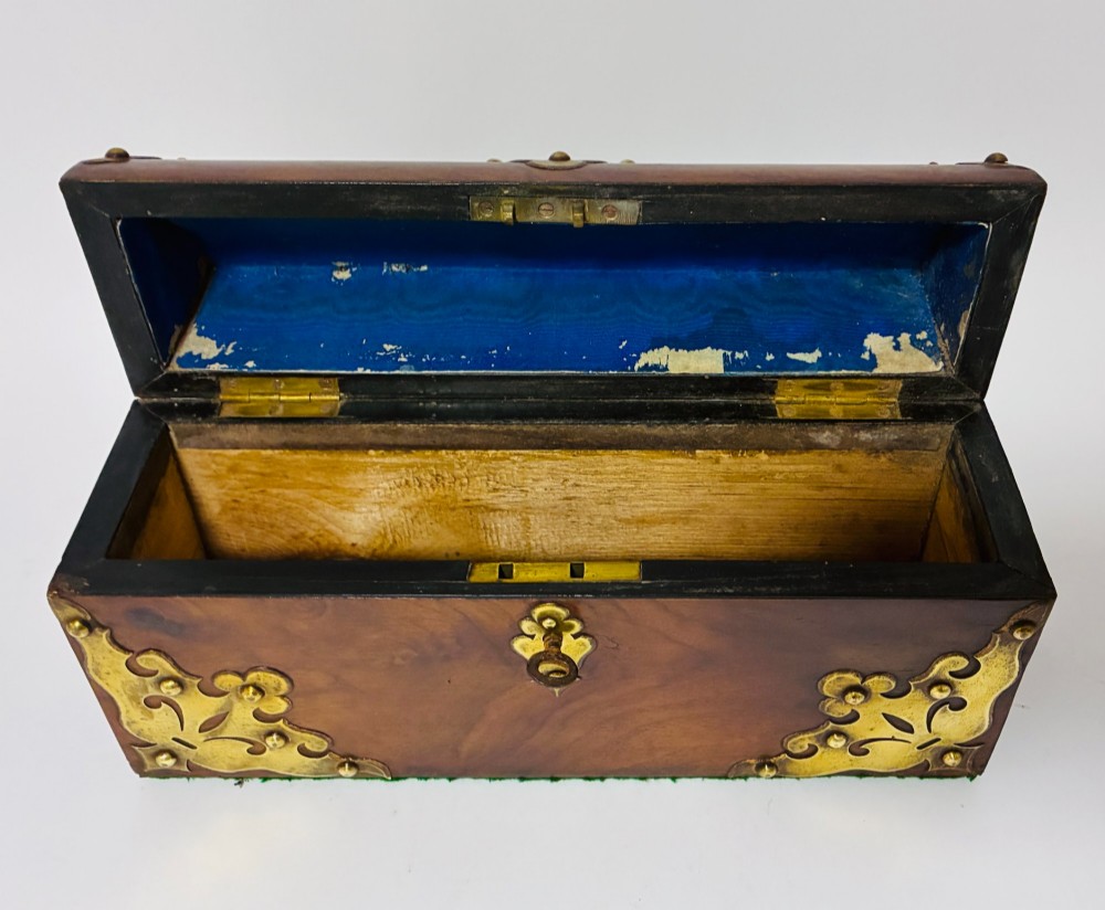 A domed Victorian walnut box featuring decorative pierced brass corner mounts and a central brass keyhole. View II