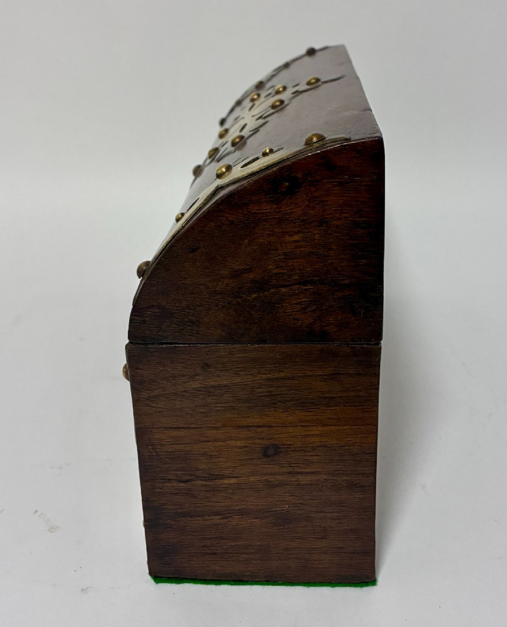 A domed Victorian walnut box featuring decorative pierced brass corner mounts and a central brass keyhole. View VI
