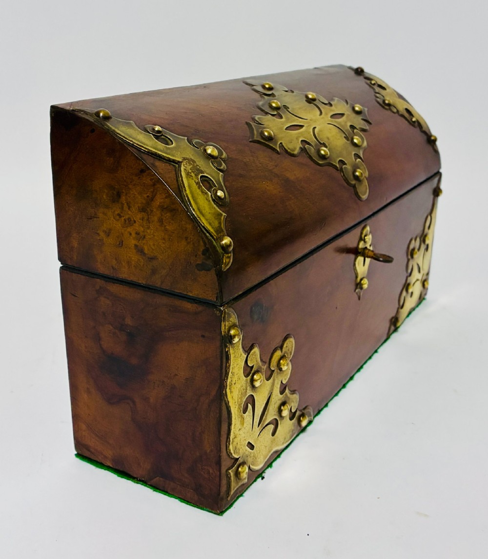 A domed Victorian walnut box featuring decorative pierced brass corner mounts and a central brass keyhole. View IX