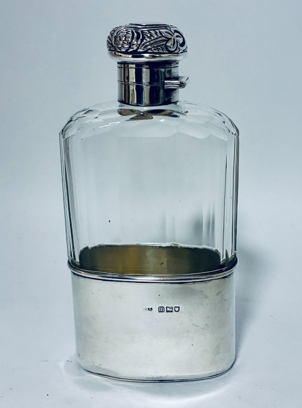 An antique cut-glass hip flask featuring a hallmarked sterling silver collar, chased cap, and a removable silver base cup engraved with the letter C. View III