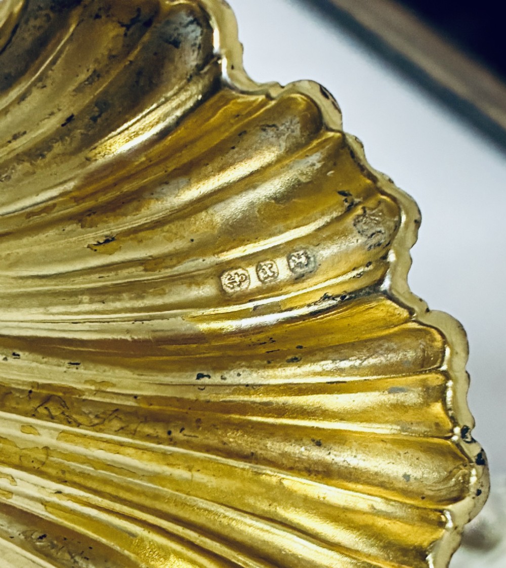 A cased set of four Victorian shell-shaped silver salt cellars with gilded interiors and two matching silver spoons in a velvet-lined box. View VII