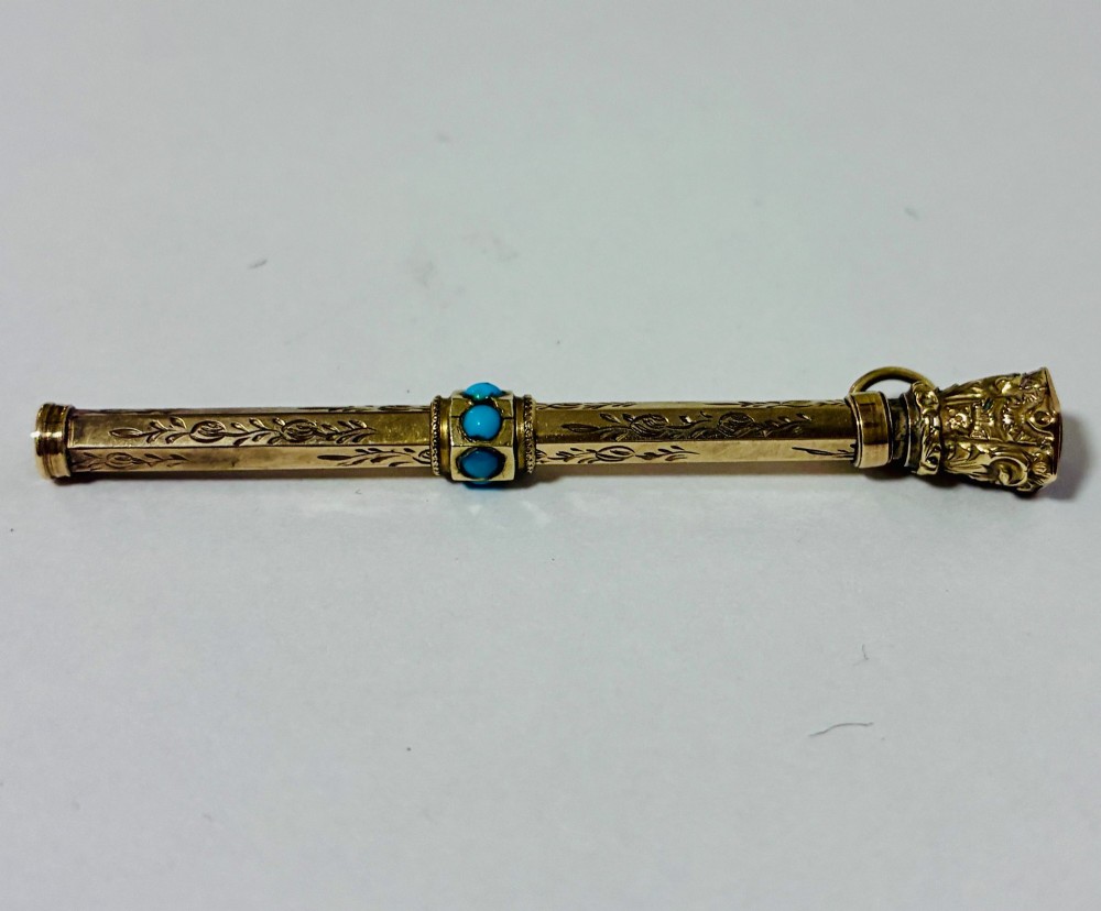 An ornate Victorian gold propelling pencil featuring engraved floral motifs, set with round turquoise cabochons and fitted with a suspension ring. View VIII