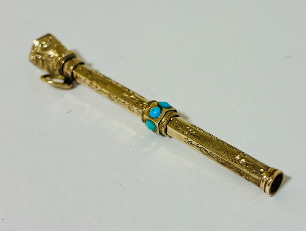An ornate Victorian gold propelling pencil featuring engraved floral motifs, set with round turquoise cabochons and fitted with a suspension ring. View IX