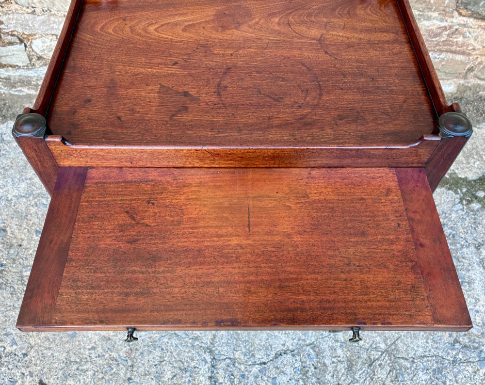 A Georgian mahogany tray top commode featuring a gallery top with pierced carrying handles, double cupboard doors, and a lower drawer on square legs. View IV