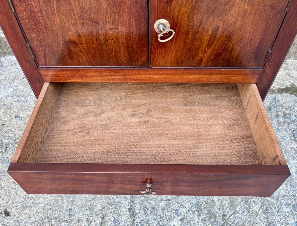 A Georgian mahogany tray top commode featuring a gallery top with pierced carrying handles, double cupboard doors, and a lower drawer on square legs. View VII