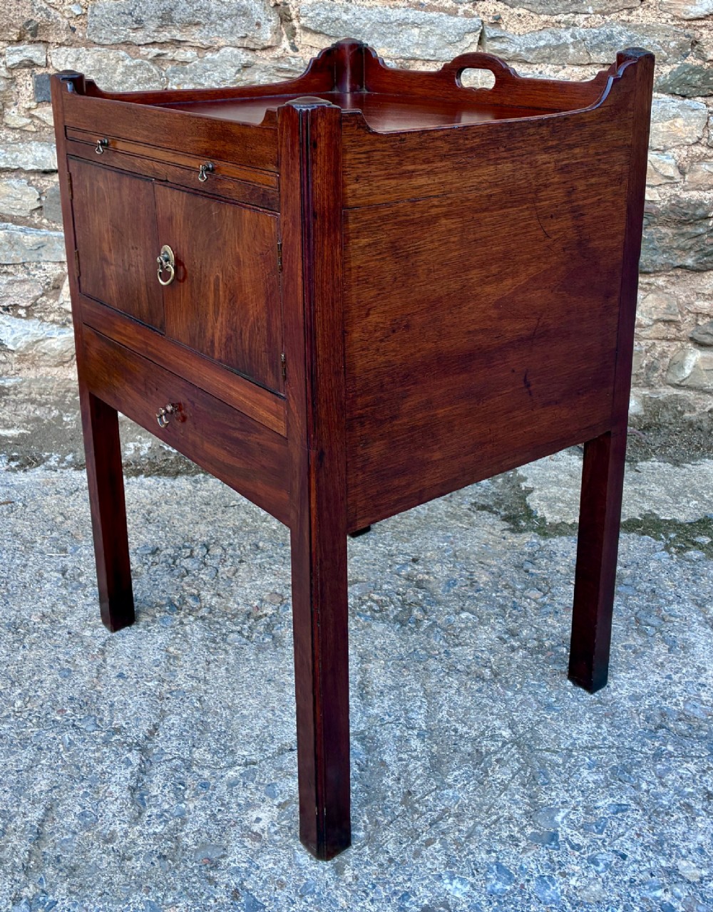 A Georgian mahogany tray top commode featuring a gallery top with pierced carrying handles, double cupboard doors, and a lower drawer on square legs. View VIII