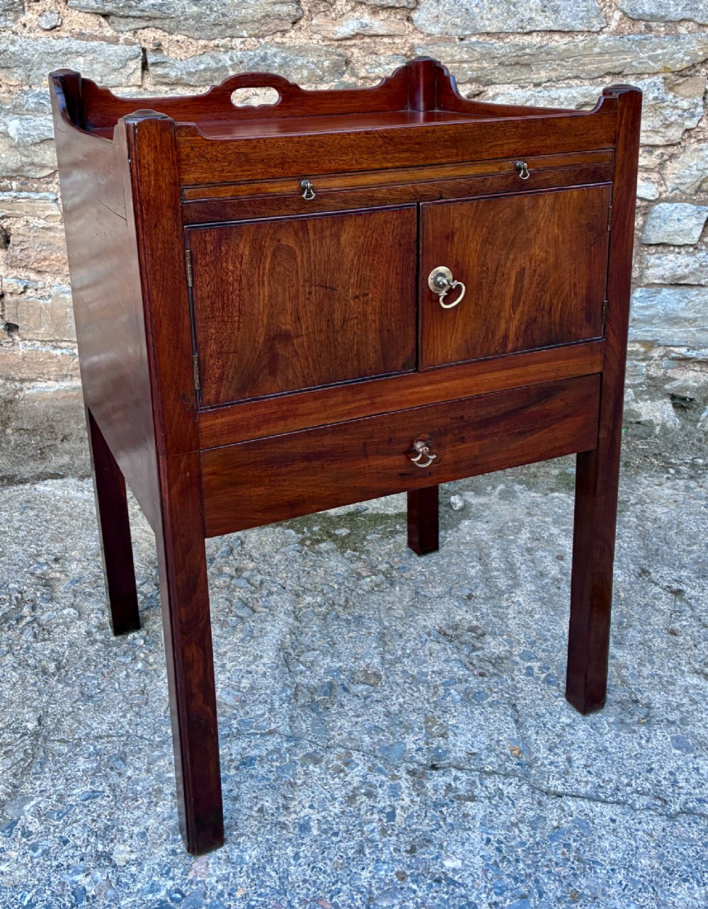 A Georgian mahogany tray top commode featuring a gallery top with pierced carrying handles, double cupboard doors, and a lower drawer on square legs. View XII