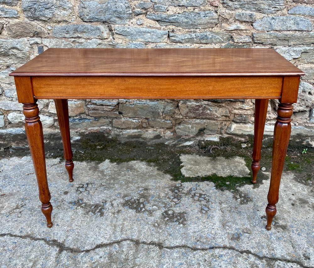 A rectangular Victorian mahogany console table featuring a smooth polished top surface, straight apron, and four turned legs.