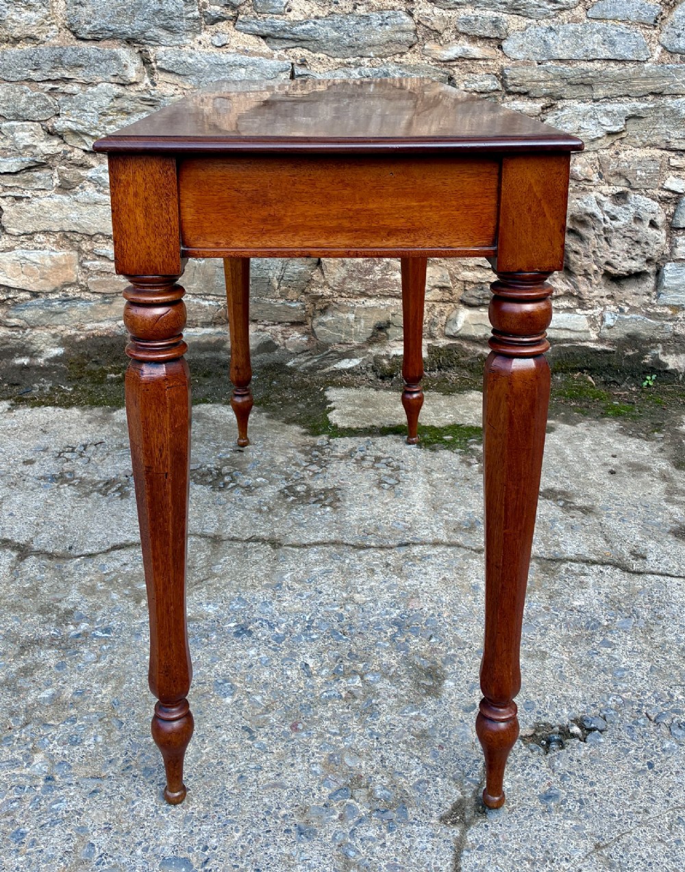 A rectangular Victorian mahogany console table featuring a smooth polished top surface, straight apron, and four turned legs. View V
