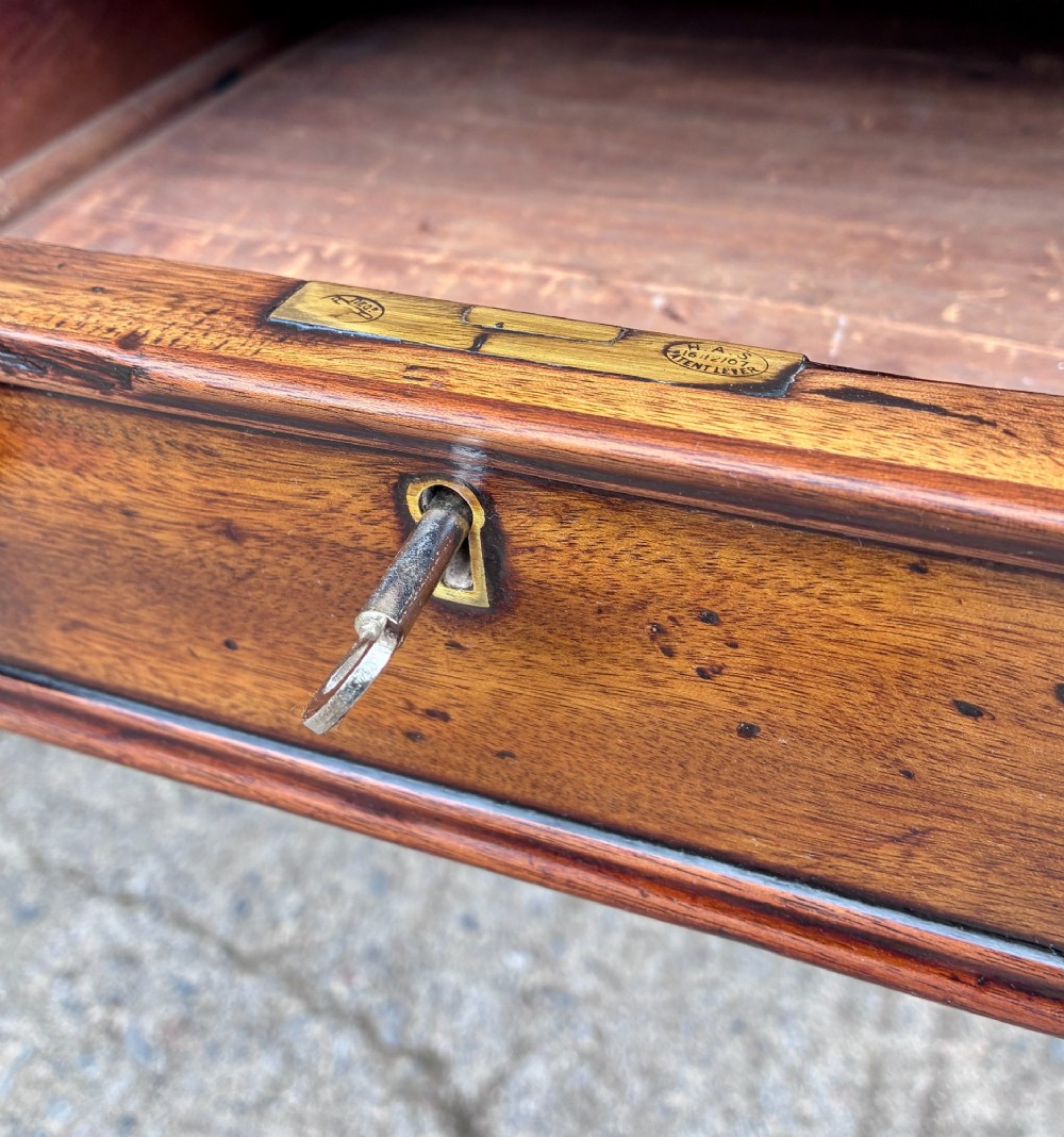 A Victorian mahogany writing table featuring a green leather top, two front drawers with turned wooden knobs, and fluted turned legs on brass castors. View VIII