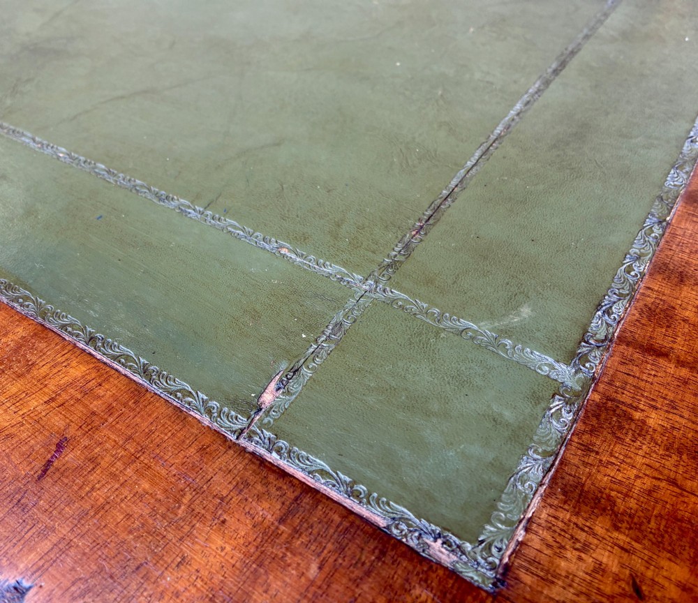 A Victorian mahogany writing table featuring a green leather top, two front drawers with turned wooden knobs, and fluted turned legs on brass castors. View IX
