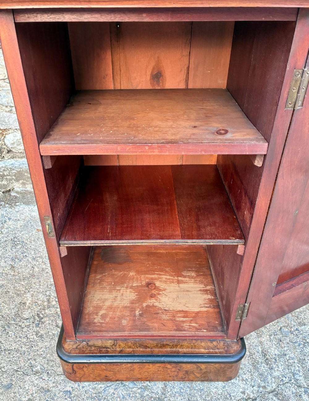 A Victorian burr walnut pot cupboard featuring a single door with ebonised moulding, a rounded top edge, shaped splashback gallery, and dark wooden knob. View IV