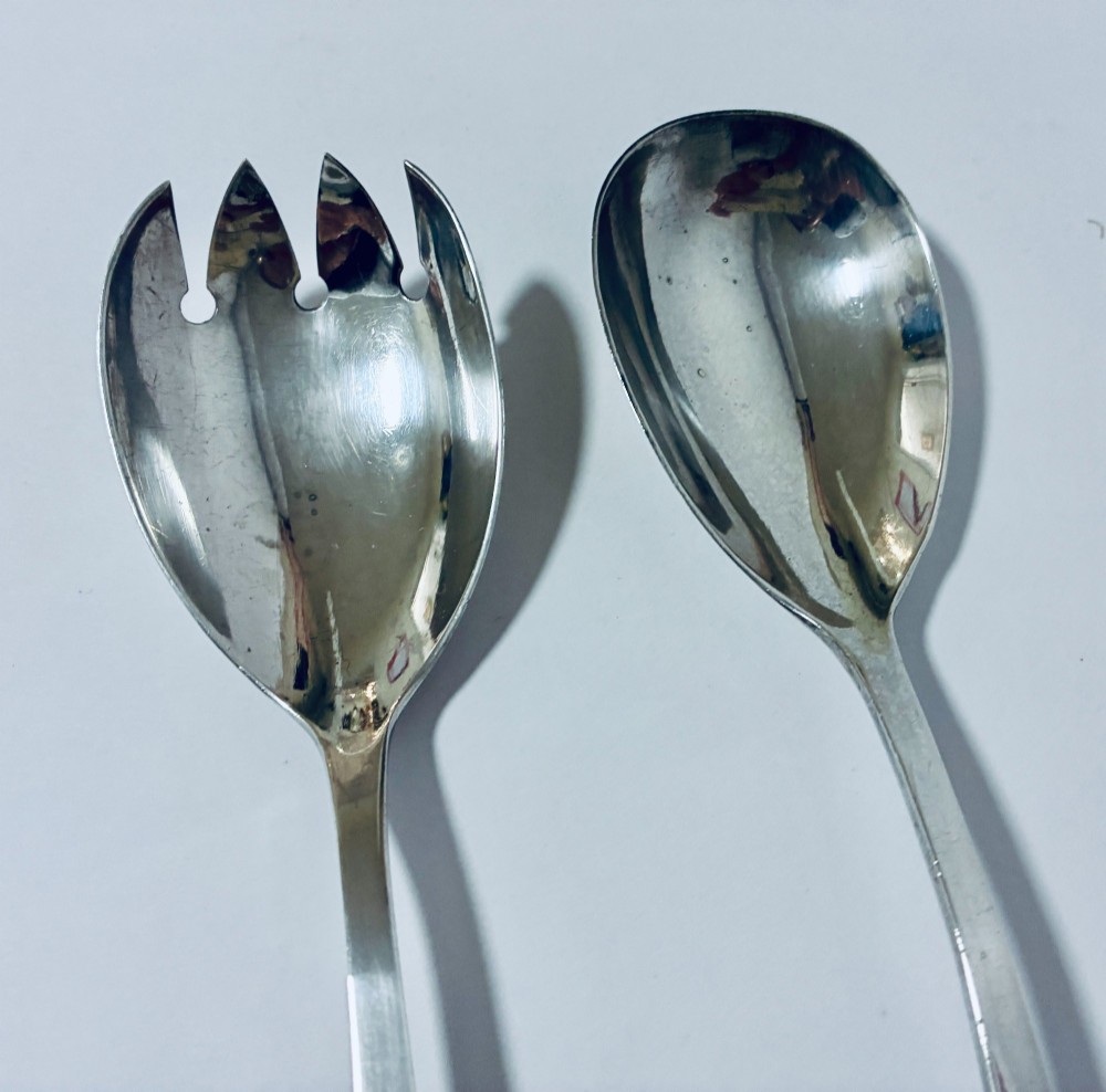 A pair of antique silver salad servers displaying planished hammered handles and polished metal serving ends. View VI