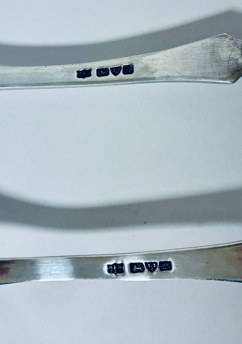 A pair of antique silver salad servers displaying planished hammered handles and polished metal serving ends. View VIII