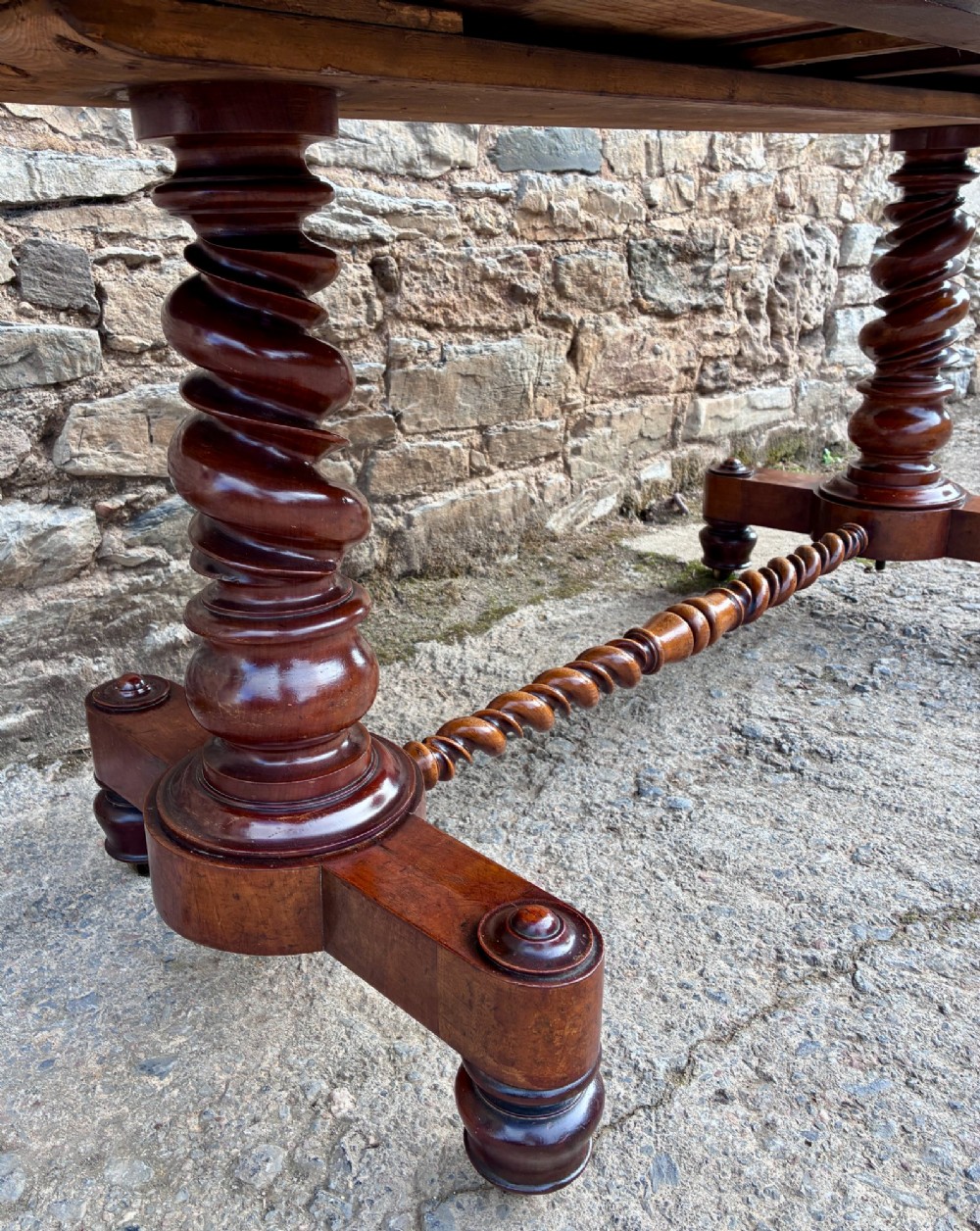 A Victorian walnut library writing table featuring a green inset leather top, carved gadrooned edge, twin drawers, and spiral barley twist legs connected by a central stretcher. View IX