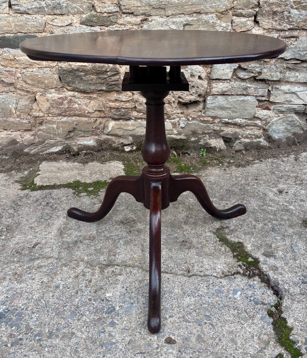 A dark brown Georgian oak tilt-top tripod table featuring a circular top, turned baluster column, and three cabriole legs. View II