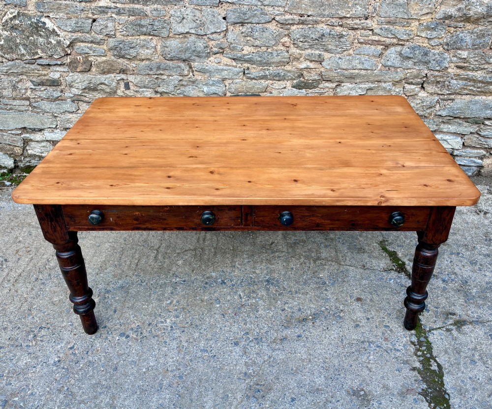 A Victorian pine farmhouse table featuring a light natural timber plank top, two frieze drawers with round wooden knobs, and four dark turned wooden legs. View II