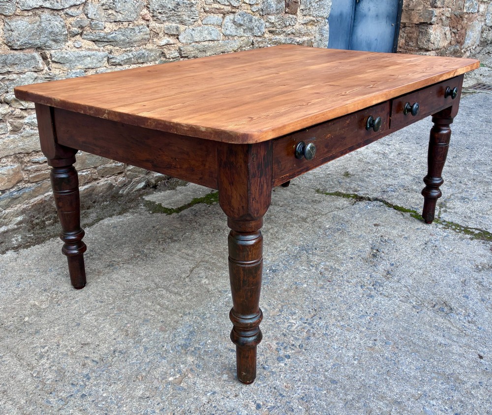 A Victorian pine farmhouse table featuring a light natural timber plank top, two frieze drawers with round wooden knobs, and four dark turned wooden legs. View III