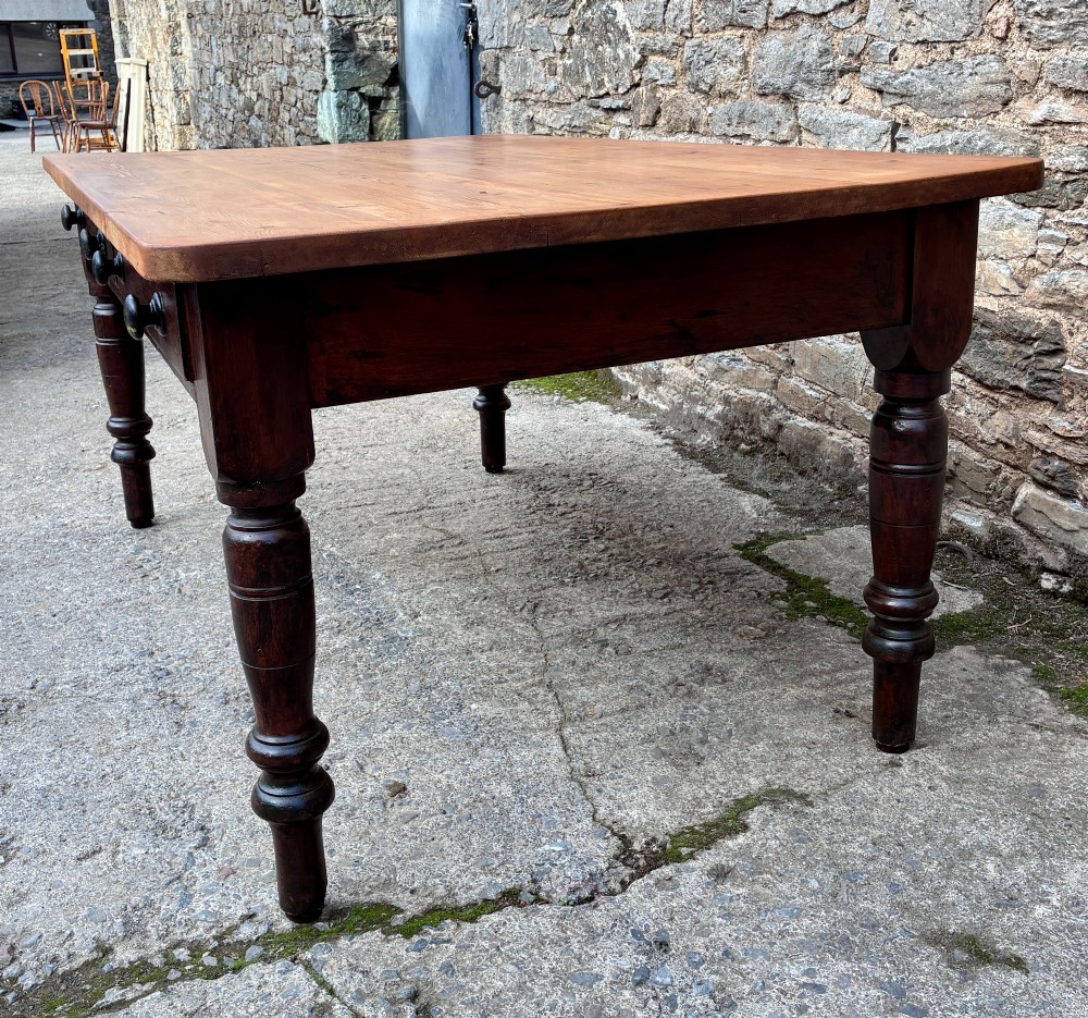 A Victorian pine farmhouse table featuring a light natural timber plank top, two frieze drawers with round wooden knobs, and four dark turned wooden legs. View VII