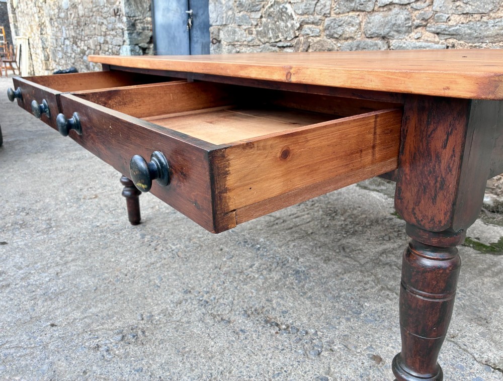 A Victorian pine farmhouse table featuring a light natural timber plank top, two frieze drawers with round wooden knobs, and four dark turned wooden legs. View IX