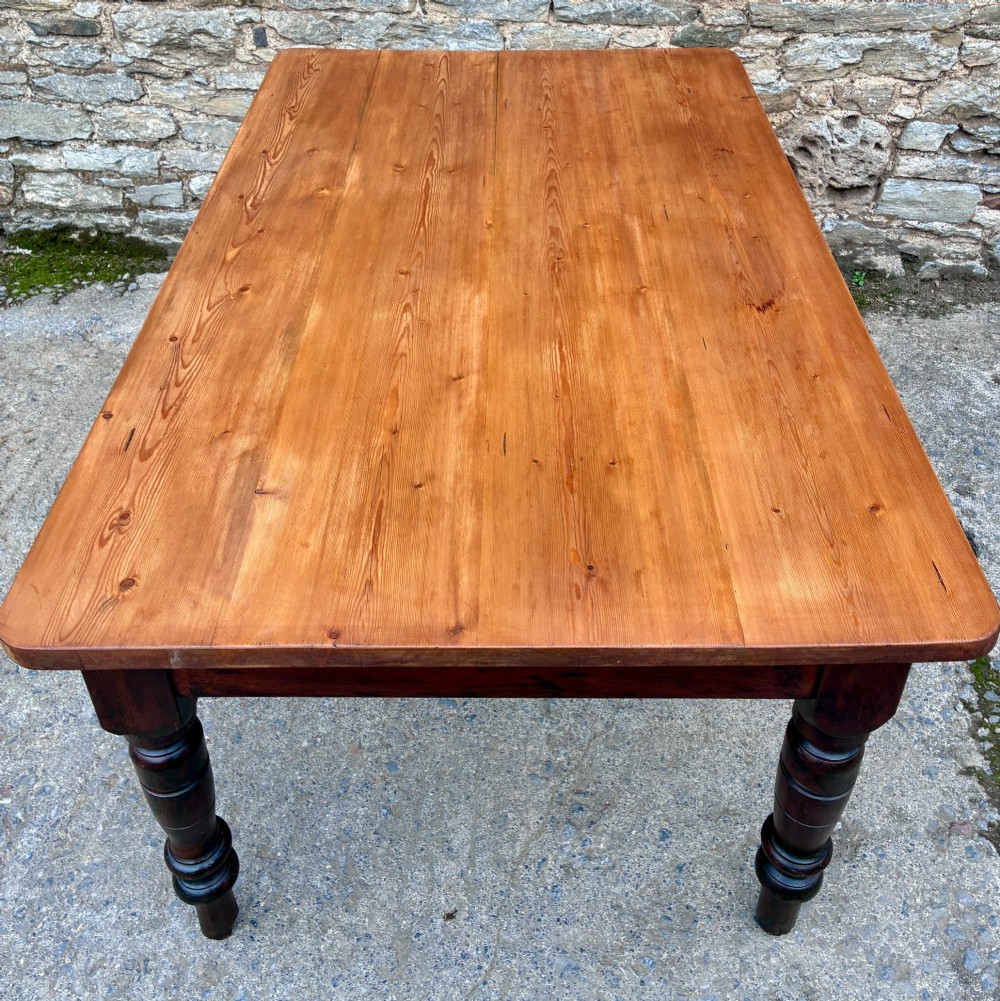 A Victorian pine farmhouse table featuring a light natural timber plank top, two frieze drawers with round wooden knobs, and four dark turned wooden legs. View XIII