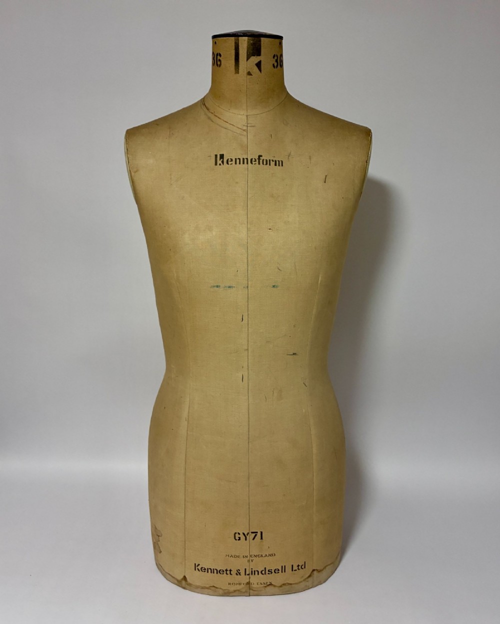 A vintage fabric-covered dressmakers mannequin torso displaying the Kenneform and Kennett and Lindsell maker marks.