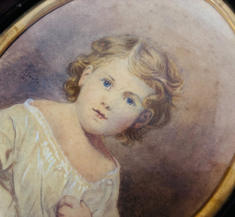 An oval Edwardian watercolour portrait depicting a young child with blonde curls, set inside a dark wooden frame with a gilt inner trim. View VIII