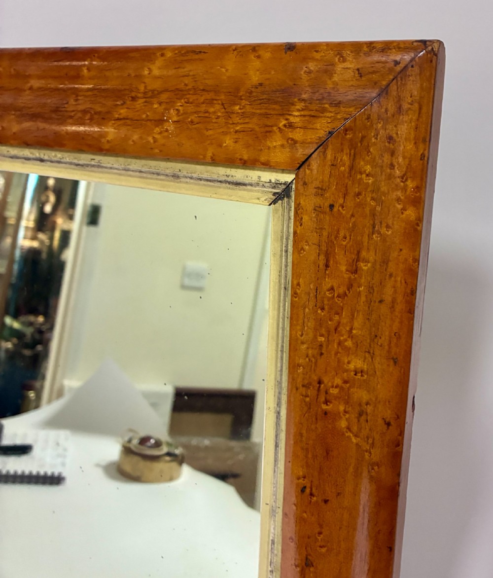 An antique rectangular birds eye maple frame featuring an inner gilt slip rim surrounding a mirror glass plate, supported by an easel stand. View II