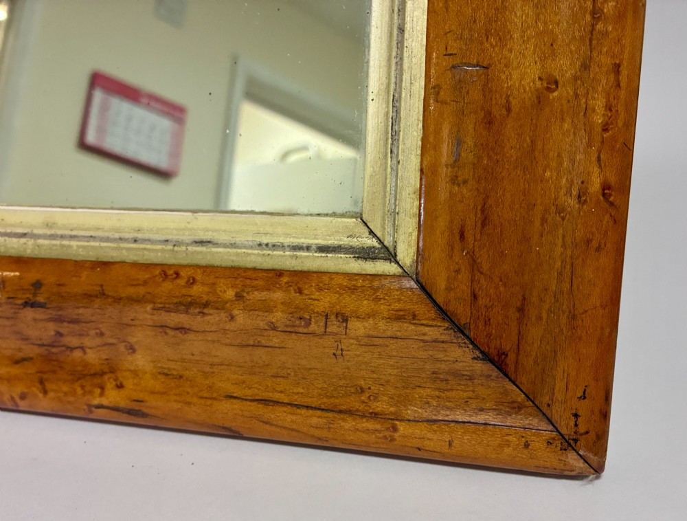 An antique rectangular birds eye maple frame featuring an inner gilt slip rim surrounding a mirror glass plate, supported by an easel stand. View III