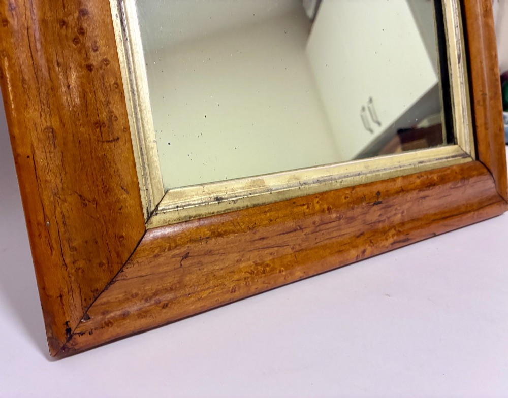 An antique rectangular birds eye maple frame featuring an inner gilt slip rim surrounding a mirror glass plate, supported by an easel stand. View IV