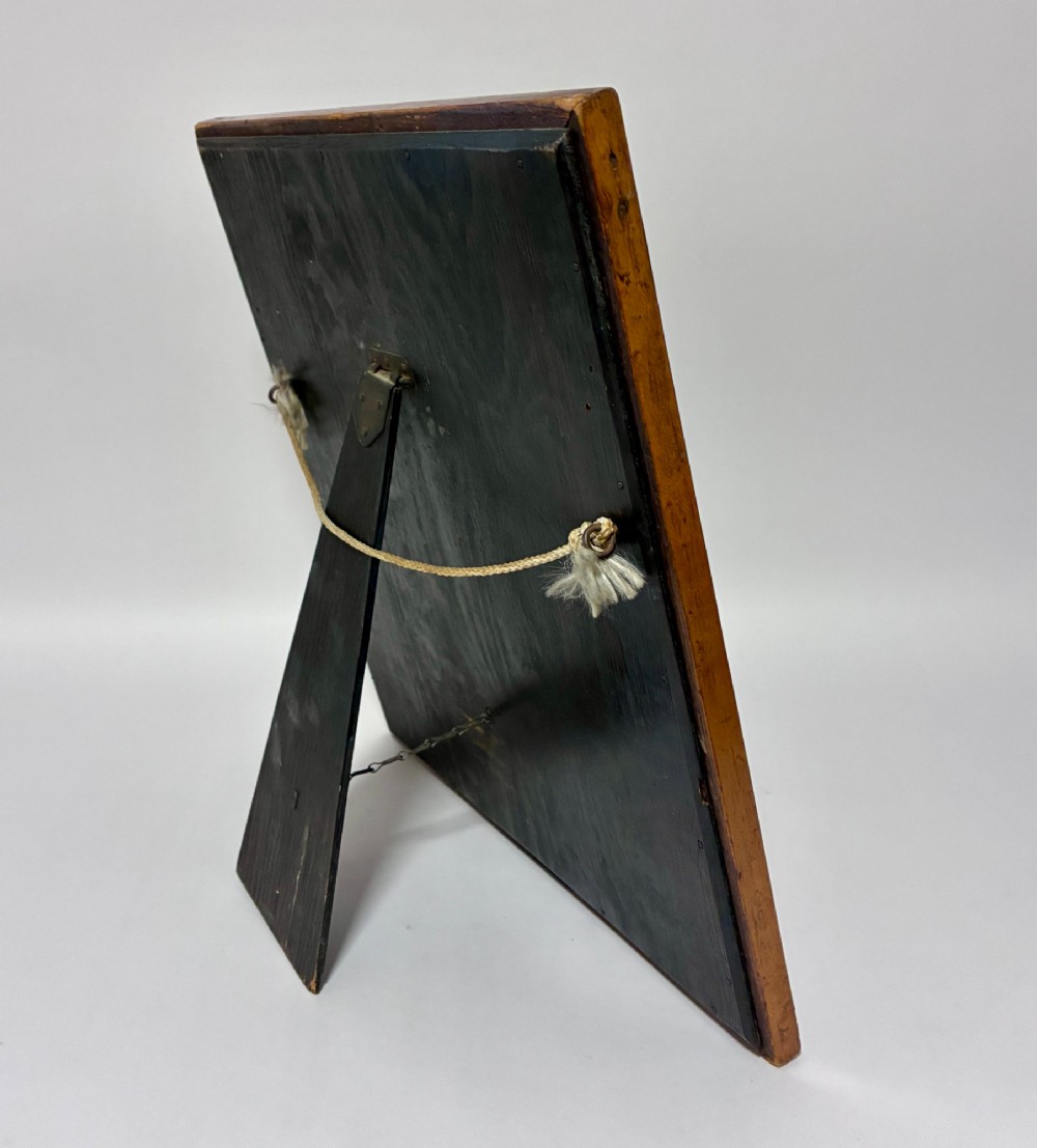 An antique rectangular birds eye maple frame featuring an inner gilt slip rim surrounding a mirror glass plate, supported by an easel stand. View VII
