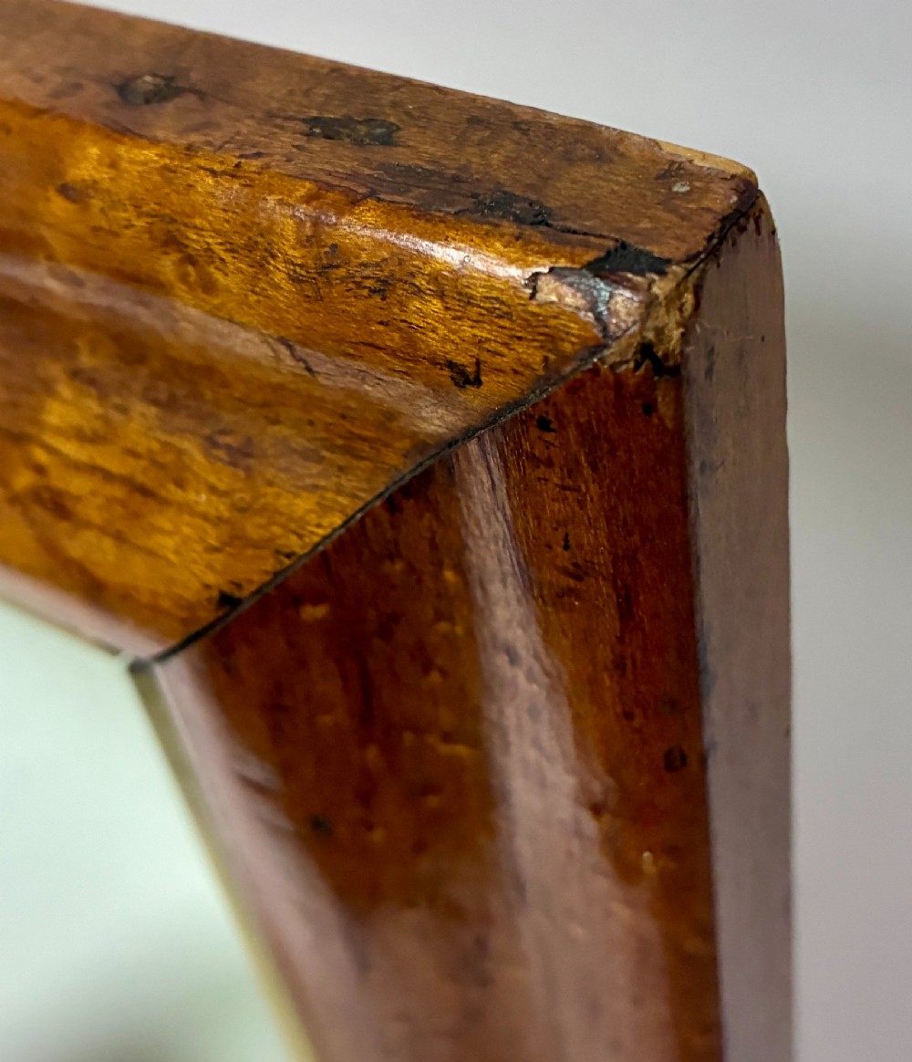 An antique rectangular birds eye maple frame featuring an inner gilt slip rim surrounding a mirror glass plate, supported by an easel stand. View VIII