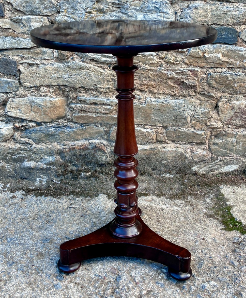 A Victorian mahogany wine table featuring a circular top supported by a turned central pedestal column resting on a tripod base.