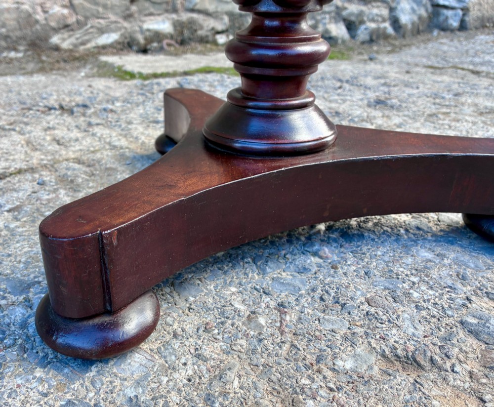 A Victorian mahogany wine table featuring a circular top supported by a turned central pedestal column resting on a tripod base. View VI